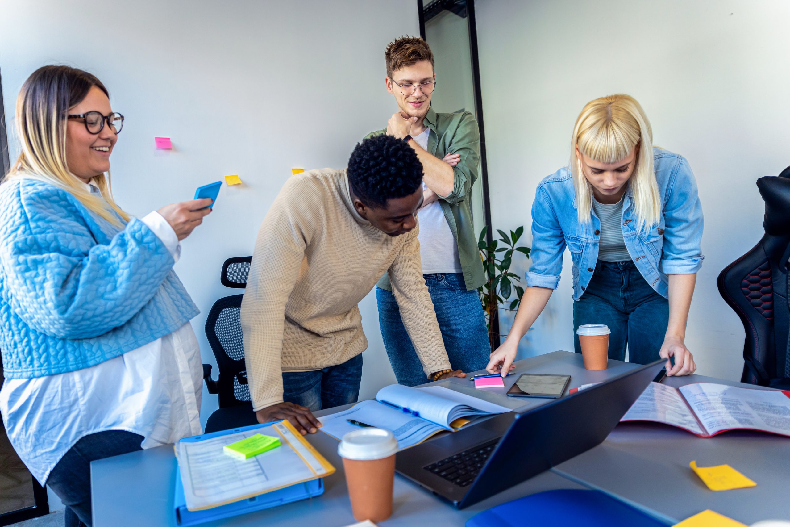 Grupo diverso colaborando alrededor de una mesa de trabajo