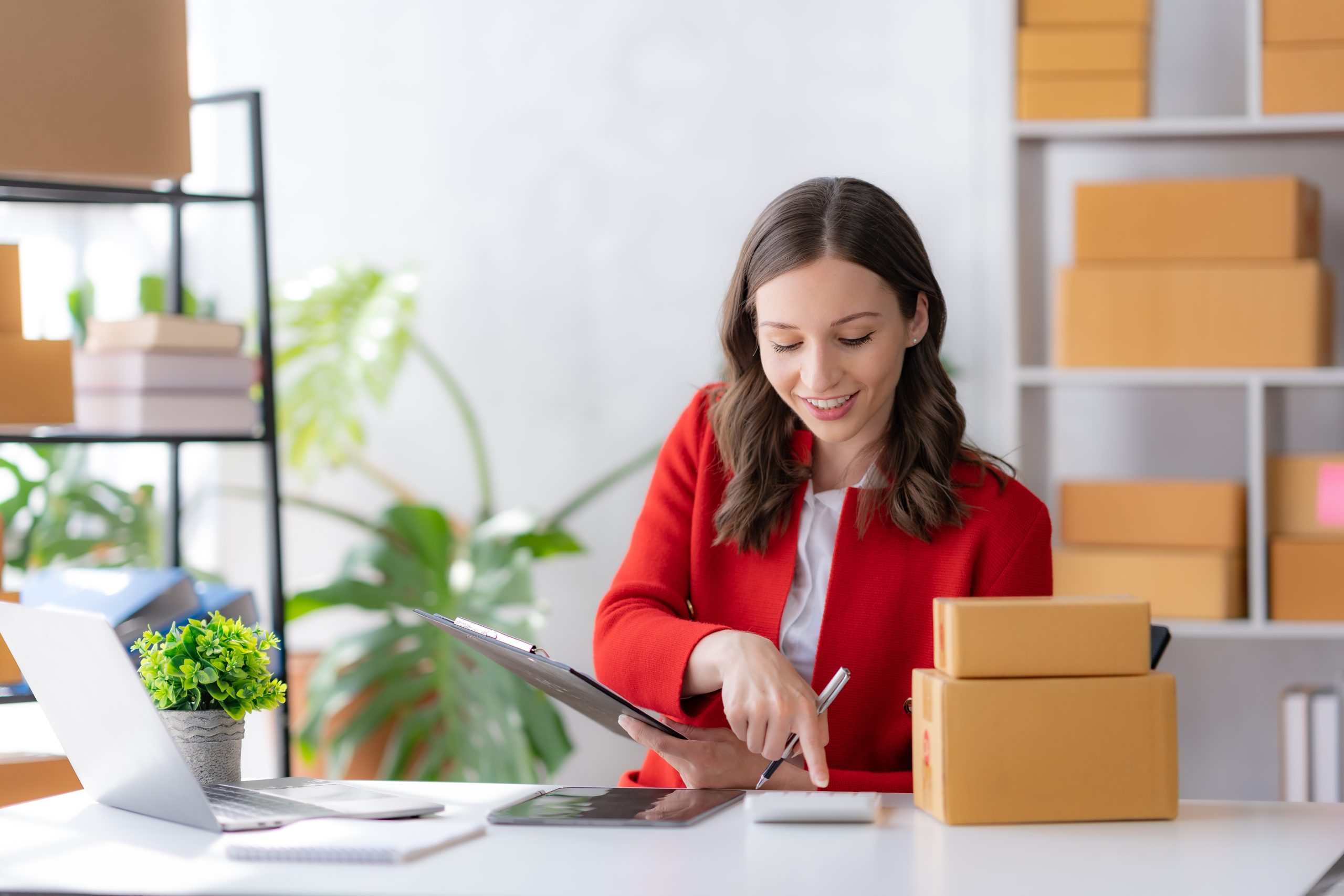 Female ecommerce business owner prepares package box for customer and delivery check balance. SME.