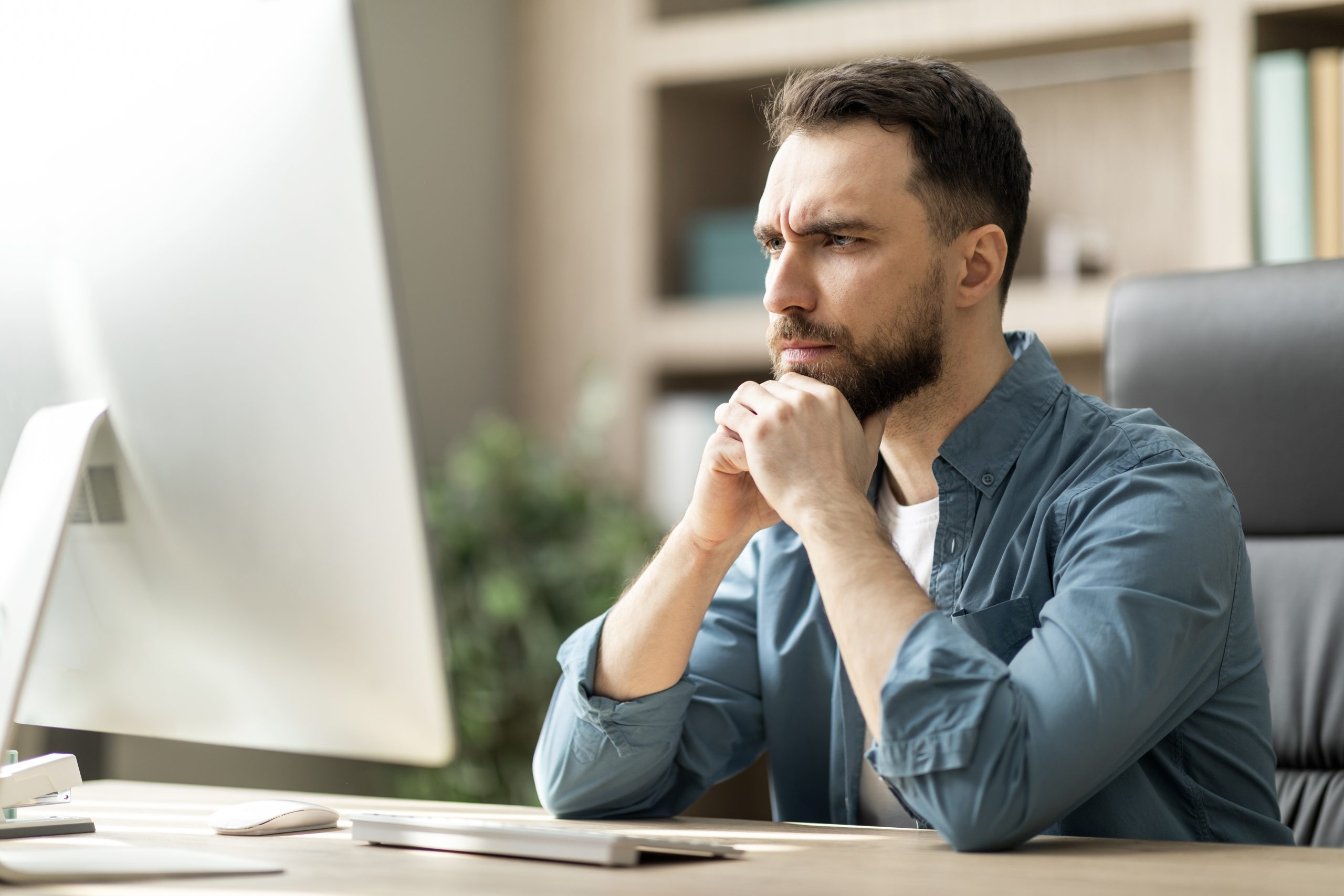 Profesional concentrado frente a pantalla en oficina moderna